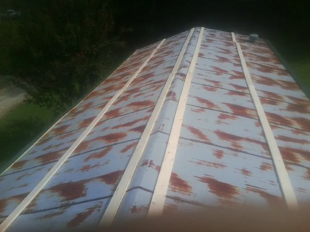 Rusted metal roof panels with new wood purlins before replacement — Storm Damage Roof Repair in Meadville by Roofing Brothers