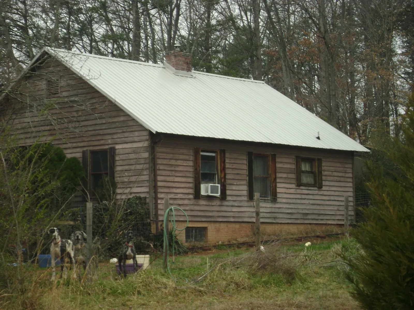 White metal roof on an old wood sided farmhouse, from a Metal Roof Installation job in Meadville